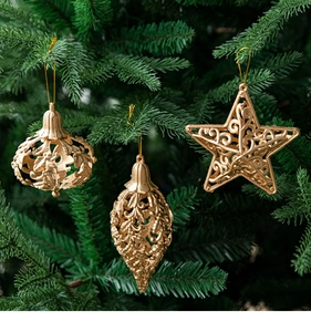 Detailed view of hollow gold Christmas ornaments set hanging on green tree branches