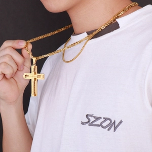 Close-up of golden stainless steel cross pendant on a thick pearl king chain necklace