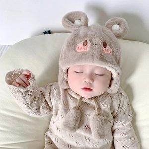 Dettaglio del cappello di peluche per neonati con orecchie di orso 3D e ricami morbidi