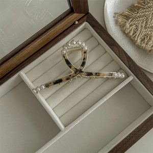 Detail of tortoise shell hair claw with pearl trim in a premium wooden jewelry box