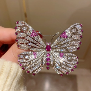 Exquisite silver butterfly brooch featuring full crystals and red sapphire accents