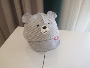 Detail of baby bear baseball cap featuring gray stripes and cute 3D bear ears on top