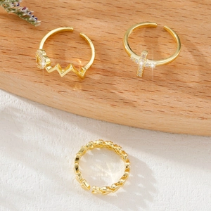 Three-piece set of golden open rings featuring a cross with zircon, heart and chain patterns