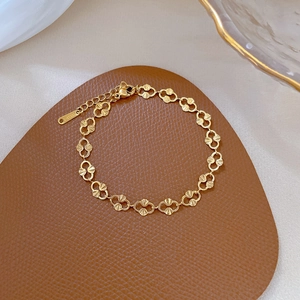 Golden titanium steel chain bracelet with shell links and lobster clasp on brown leather