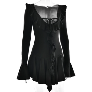 Detail of black mini dress featuring deep V-neckline with ruffles and lace-up front ties