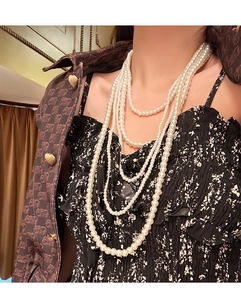 Close-up of elegant multi-layer glass pearl necklace draped on a fashion model