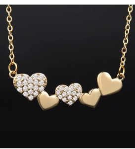 Detail of gold heart pendant with sparkling zircon inlay on a black background