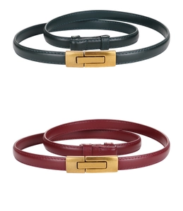Detail of dark green and burgundy slim leather belts with gold rectangular buckles