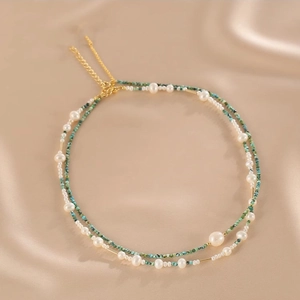 Detail of double-layer necklace with natural pearls, turquoise beads and gold tubes