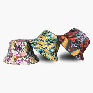 Three stylish bucket hats featuring floral patterns and abstract graffiti art prints