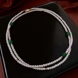 Double-layer pearl necklace with green agate beads and gold spacers on black display