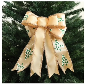 Macro detail of Christmas ribbon bow with green tree patterns and gold glitter edges
