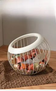 Macro shot of spherical metal coffee capsule holder in cream white with side logo