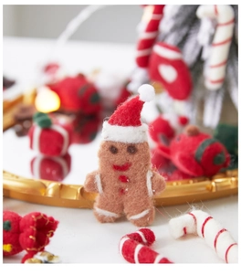 Close-up of wool felt gingerbread man ornament on golden tray with festive Christmas decor