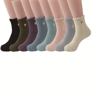 Detail showing eight pairs of coral fleece socks with embroidered gold hearts in various colors
