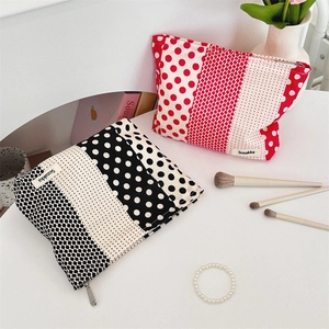 Detailed close-up of floral and polka dot fabric makeup bags with zipper and logo label