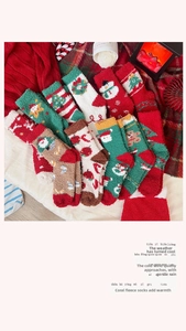 Christmas coral fleece socks with Santa and snowman patterns on a cozy festive blanket