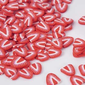 Flat lay of colorful polymer clay strawberry slices for DIY crafts and slime accessories