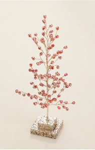 Close-up of red berry Christmas tree ornament with a golden glitter square base