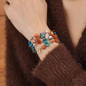 Close-up of bohemian multi-layer bracelet featuring irregular colorful shell beads