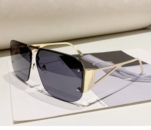 Detailed close-up of golden metal semi-rimless aviator sunglasses with dark gray lenses