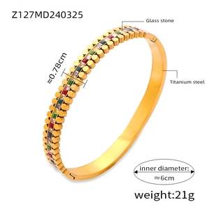 Detailed side view of 18k gold plated titanium bangle with crown pattern and gems