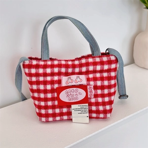 Detail of red and white plaid tote bag with cherry patch and denim handles