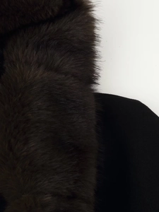 Close-up detail of the premium black faux fur trim on the hooded coat collar