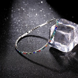 Macro shot of silver single-row tennis bracelet with rainbow gradient crystals and ice cube