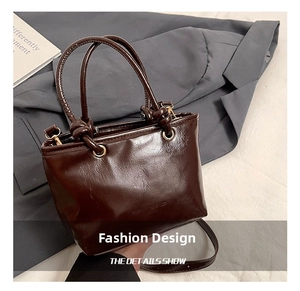 Détail du sac à main en cuir marron brillant avec poignée nouée et finitions dorées