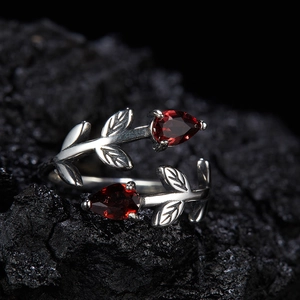 Detailed shot of leaf design silver ring with two pear-cut red garnet stones