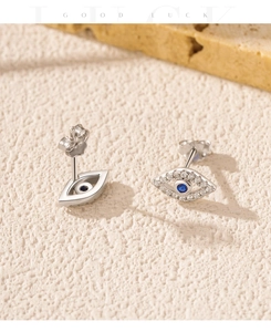 Detail view of S925 silver evil eye studs with blue crystals and sparkling white zircons