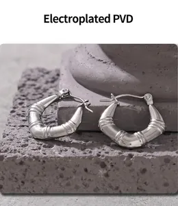 Vue macro de boucles d'oreilles argentées texture bambou avec placage PVD