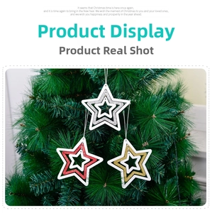 Close-up of glittery hollow star ornaments in red, gold, and silver on Christmas tree