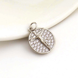 Micro shot of a silver crucifix pendant with crystal halo and religious engraving