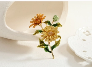 Close-up of yellow and orange gradient daisy flower brooch with enamel finish