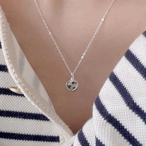 Minimalist 925 sterling silver heart necklace with zebra stone pendant worn on a model