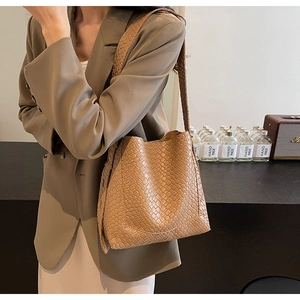 Detailed view of camel woven texture bucket bag with matching wide shoulder strap