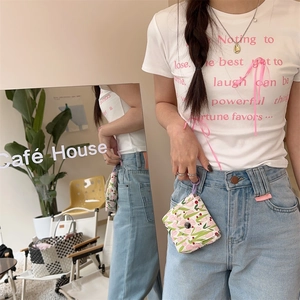 Mini floral pouch with snap button shown hanging on blue jeans as a portable accessory