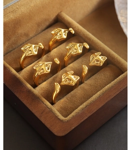 Detailed close-up of golden fox head open rings neatly arranged in a premium wooden jewelry box