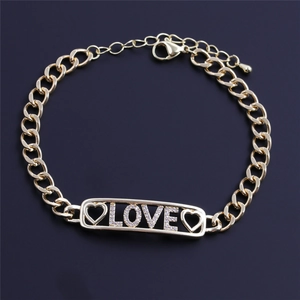 Bracelet chaîne LOVE doré élégant avec zircons et cœur sur fond violet profond