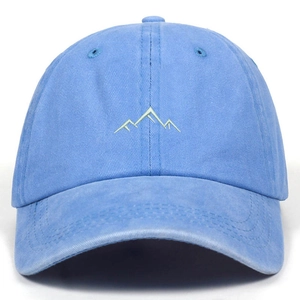 Light blue washed cotton baseball cap with green mountain embroidery on white background