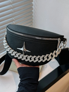 Close-up of black lychee texture leather belt bag with silver chain and star detail