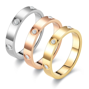 Detailed view of three polished titanium steel rings in silver, gold, and rose gold finishes