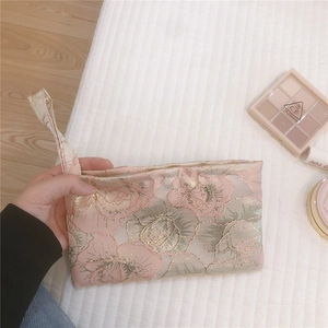 Detail of rose jacquard mini canvas bag with golden threads and hand strap