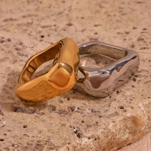 Minimalist square geometric ring in 18K gold and silver finishes on stone background