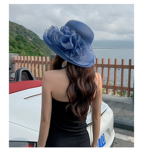 Detail of navy blue sun hat with large organza flower and wide brim for beach vacation