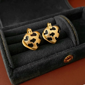 Vintage gold matte heart earrings with black enamel leopard print on velvet background