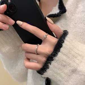 Detailed shot of silver butterfly and heart rings set worn on a white sweater