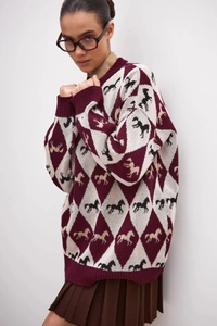 Detail of diamond horse jacquard pattern on vintage oversize knit sweater with ribbed cuffs